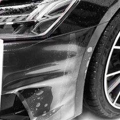 protective film being placed on black car fender